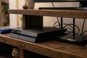 Игровая консоль PS4 и роутер с подключённым сетевым кабелем