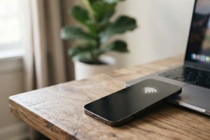 Смартфон рядом с ноутбуком на рабочем столе раздаёт интернет